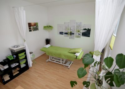 stimmungsvoller Behandlungsraum in weiß und sanften Grüntönen