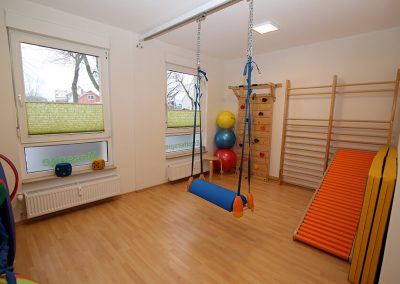 Behandlungsraum mit Sprossenleiter, Kletterwand und Schaukel